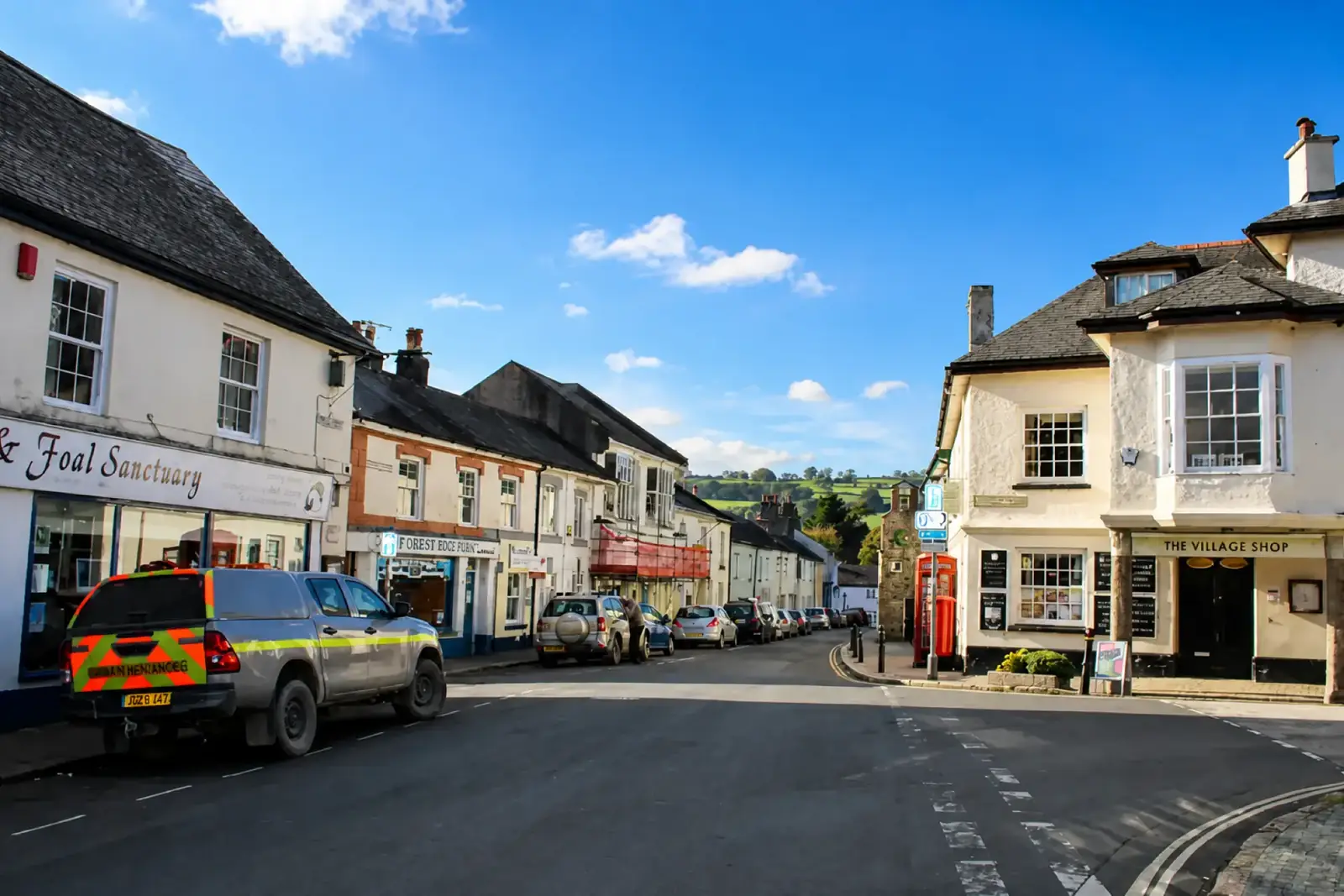 The main street through South Brent with the village shop and hills beyond
