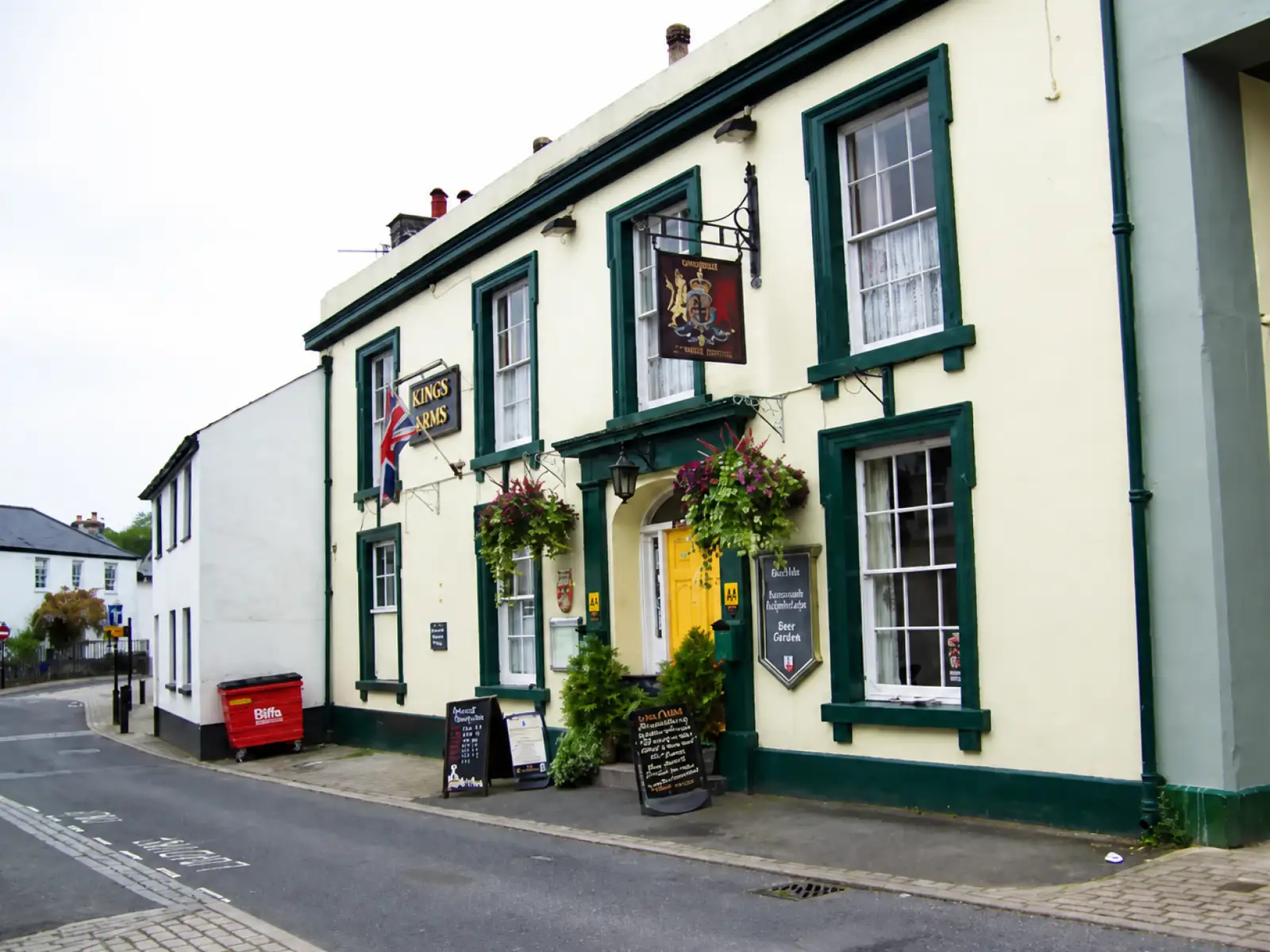 A traditional Devon village pub frontage with hanging baskets and chalkboards